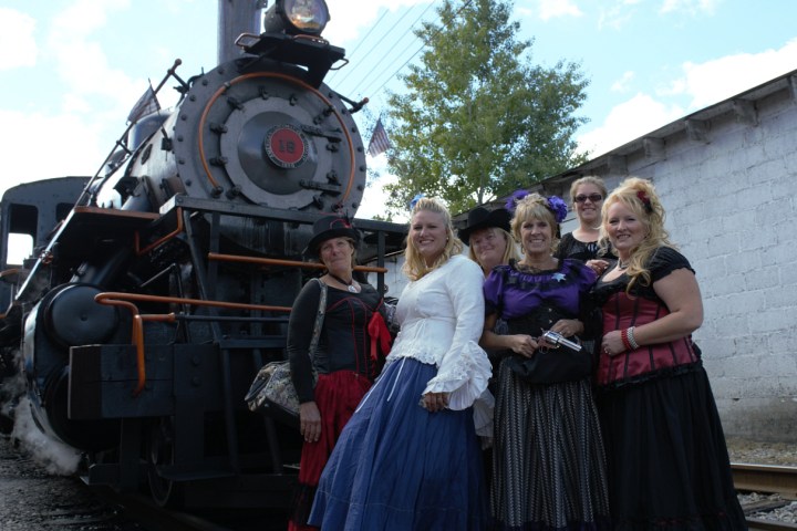 a group of people standing next to a train
