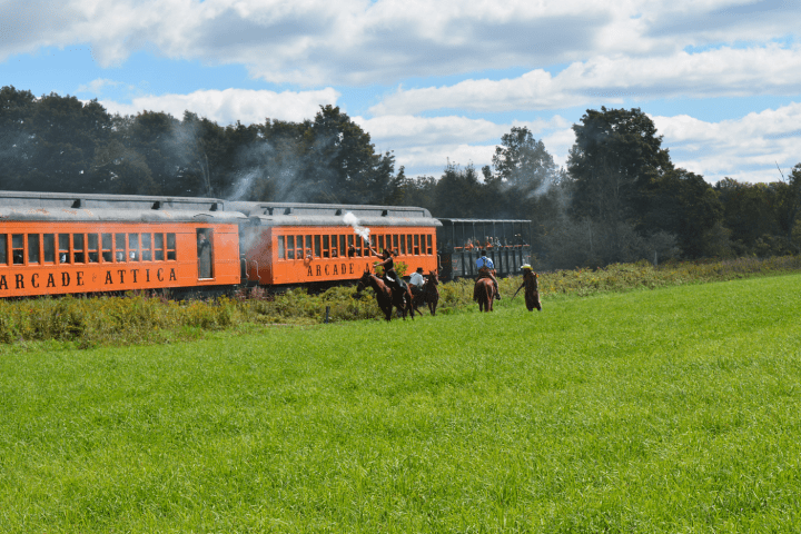 a train traveling down train tracks near a field