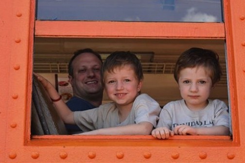a little boy sitting in front of a window