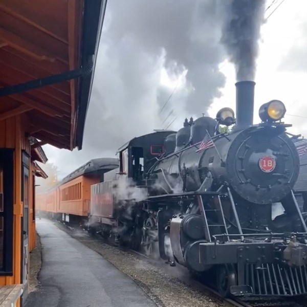 a steam train on a track with smoke coming out of it