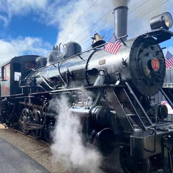 a steam engine on a train track with smoke coming out of it