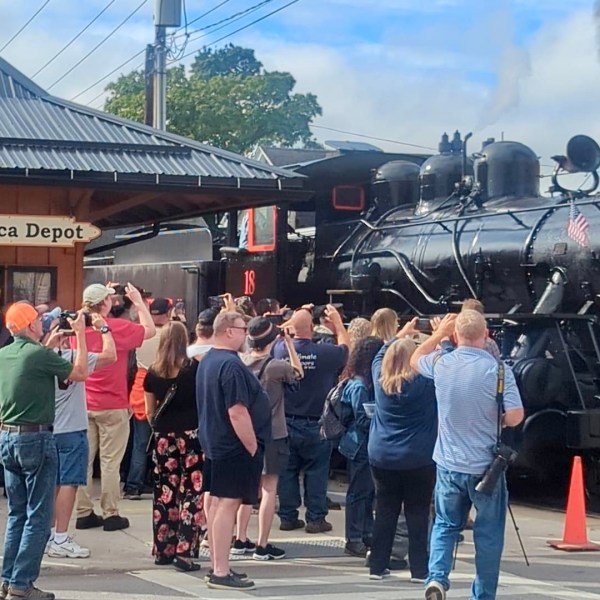 a group of people waiting to board a train
