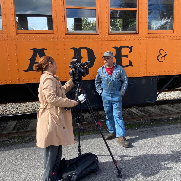 a group of people standing next to a train