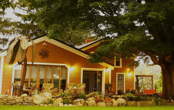 a herd of sheep grazing in front of a house