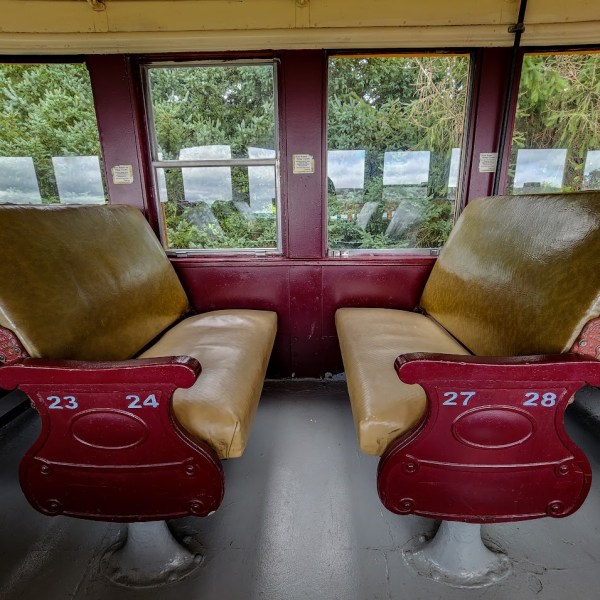 a brown leather couch sitting on top of a suitcase