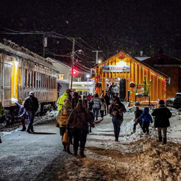 a group of people walking down a street next to a horse