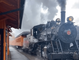 a steam train on a track with smoke coming out of it